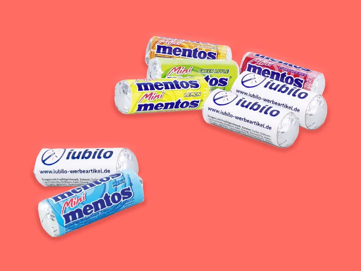 Mehrere Mini-Mentos-Bonbonrollen in verschiedenen Geschmacksrichtungen und bunten Verpackungen sind auf einem korallenroten Hintergrund verstreut. Einige Rollen zeigen Branding und Website-Text.