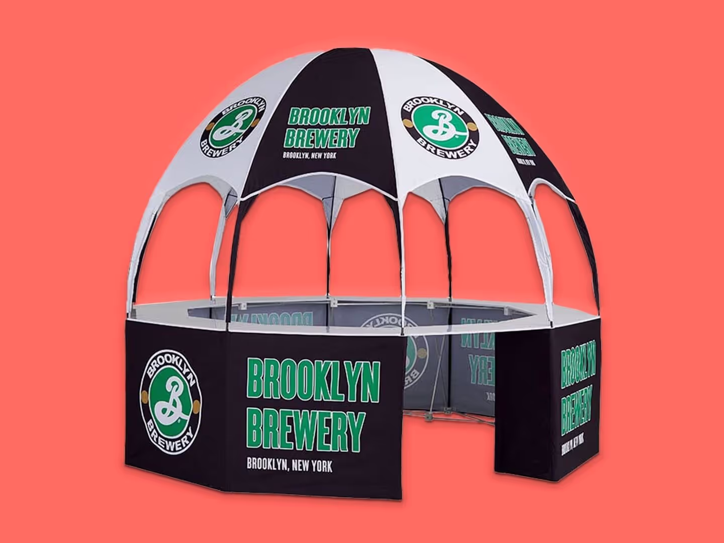 Ein großes kuppelförmiges Veranstaltungszelt mit dem Aufdruck "Brooklyn Brewery, Brooklyn, New York" und dem grün-weißen Logo der Brauerei auf dem Vordach und den Seitenwänden vor einem einfarbigen korallenroten Hintergrund.